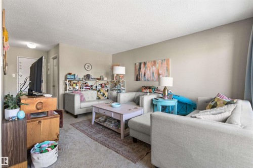 Living room with light colored carpet and a textured ceiling - 304 11420 40 Avenue Nw, Edmonton, AB - Indoor Photo Showing Living Room