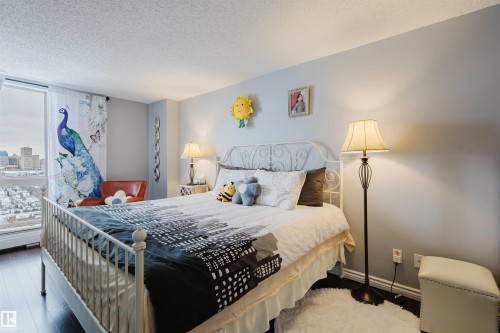 Bedroom featuring a textured ceiling and wood finished floors - 1803 10149 Saskatchewan Drive, Edmonton, AB - Indoor Photo Showing Bedroom