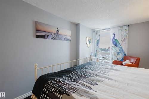 Bedroom featuring a textured ceiling and baseboards - 1803 10149 Saskatchewan Drive, Edmonton, AB - Indoor Photo Showing Bedroom