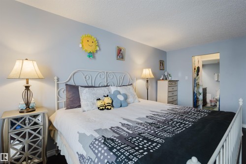 Bedroom featuring a textured ceiling and a spacious closet - 1803 10149 Saskatchewan Drive, Edmonton, AB - Indoor Photo Showing Bedroom
