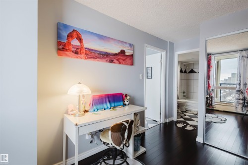 Office area featuring a textured ceiling and dark wood-style flooring - 1803 10149 Saskatchewan Drive, Edmonton, AB - Indoor