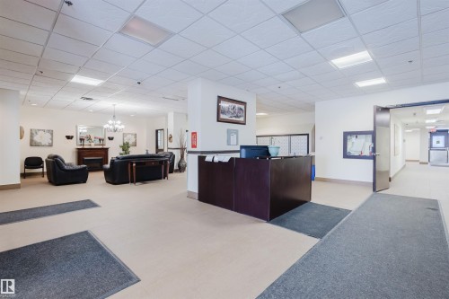 Reception featuring a paneled ceiling, hanging lights, and a fireplace - 1803 10149 Saskatchewan Drive, Edmonton, AB - Indoor Photo Showing Other Room