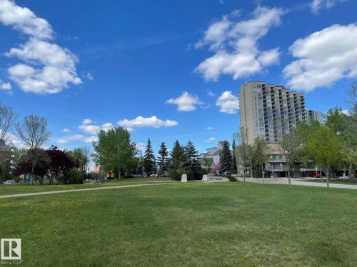 Expansive green space with a walking path, surrounded by mature trees and views of nearby buildings - 1803 10149 Saskatchewan Drive, Edmonton, AB - Outdoor