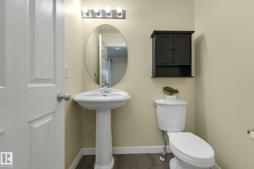 Half bathroom with toilet and dark wood-style floors - 2348 28B Avenue, Edmonton, AB - Indoor Photo Showing Bathroom