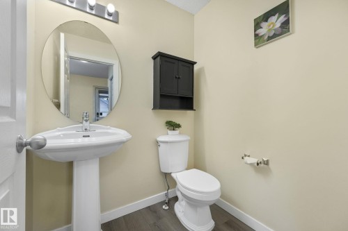 Half bathroom featuring toilet and dark wood-type flooring - 2348 28B Avenue, Edmonton, AB - Indoor Photo Showing Bathroom