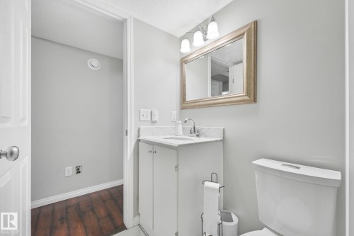 Basement bathroom with vanity, dark wood-type flooring, and a textured ceiling - 2348 28B Avenue, Edmonton, AB - Indoor Photo Showing Bathroom