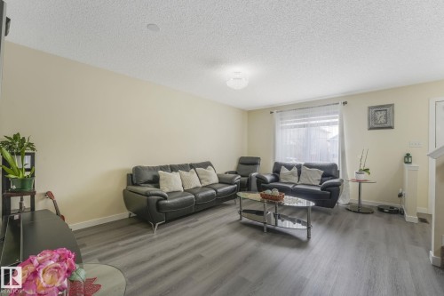 Living room with wood finished floors and a textured ceiling - 2348 28B Avenue, Edmonton, AB - Indoor Photo Showing Living Room