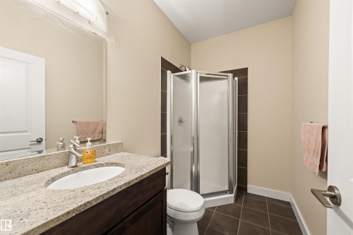 Full bathroom with a stall shower, dark tile patterned floors, and vanity - 29 11518 76 Avenue, Edmonton, AB - Indoor Photo Showing Bathroom