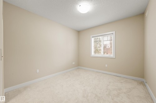 Unfurnished room with light colored carpet and a textured ceiling - 29 11518 76 Avenue, Edmonton, AB - Indoor Photo Showing Other Room