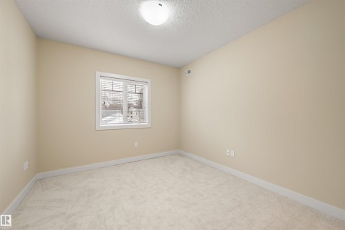 Unfurnished room with light colored carpet and a textured ceiling - 29 11518 76 Avenue, Edmonton, AB - Indoor Photo Showing Other Room