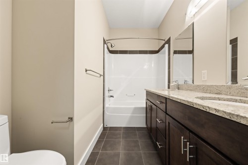 Bathroom with double vanity, dark tile patterned floors, and  shower combination - 29 11518 76 Avenue, Edmonton, AB - Indoor Photo Showing Bathroom