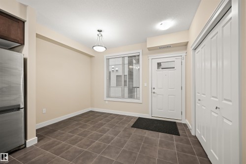Entryway with a textured ceiling and dark tile patterned flooring - 29 11518 76 Avenue, Edmonton, AB - Indoor Photo Showing Other Room