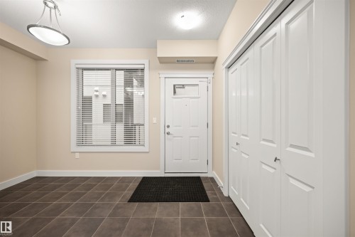 Foyer entrance featuring dark tile patterned flooring and a textured ceiling - 29 11518 76 Avenue, Edmonton, AB - Indoor Photo Showing Other Room