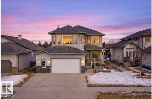 View of front of house featuring stone siding, concrete driveway, and a shingled roof - 19 Rosemount Boulevard, Beaumont, AB - Outdoor With Facade