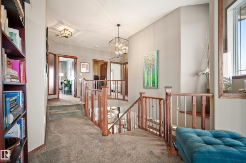 Corridor featuring an upstairs landing, carpet floors, hanging lights, and healthy amount of natural light - 19 Rosemount Boulevard, Beaumont, AB - Indoor Photo Showing Other Room