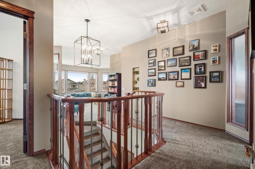 Corridor featuring carpet floors, an upstairs landing, hanging lights, healthy amount of natural light, and a textured ceiling - 19 Rosemount Boulevard, Beaumont, AB - Indoor Photo Showing Other Room
