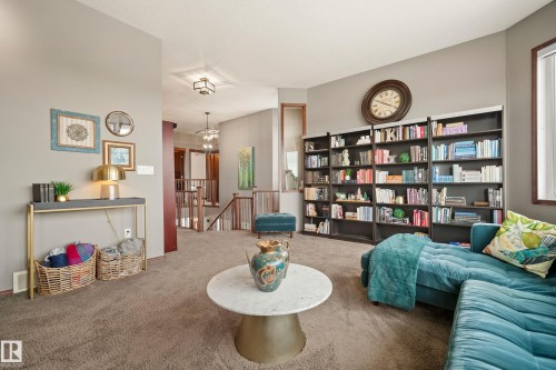 Living area with an upstairs landing, carpet floors, and a chandelier - 19 Rosemount Boulevard, Beaumont, AB - Indoor Photo Showing Living Room