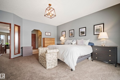Carpeted bedroom with arched walkways and a closet - 19 Rosemount Boulevard, Beaumont, AB - Indoor Photo Showing Bedroom