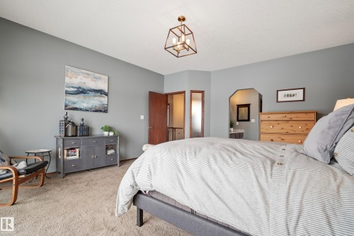 Bedroom with carpet floors and a chandelier - 19 Rosemount Boulevard, Beaumont, AB - Indoor Photo Showing Bedroom