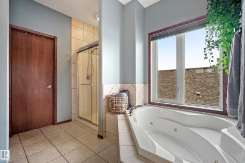 Full bath with a shower stall, a whirlpool tub, and light tile patterned flooring - 19 Rosemount Boulevard, Beaumont, AB - Indoor Photo Showing Bathroom