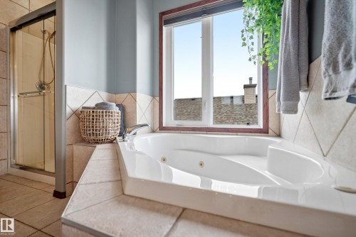 Bathroom featuring a tub with jets, a shower stall, and tile walls - 19 Rosemount Boulevard, Beaumont, AB - Indoor Photo Showing Bathroom