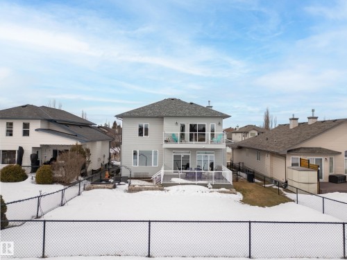 Snow covered rear of property featuring a balcony, a fenced backyard, and a patio - 19 Rosemount Boulevard, Beaumont, AB - Outdoor