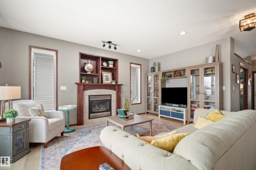 Living room featuring a tile fireplace, wood finished floors, and recessed lighting - 19 Rosemount Boulevard, Beaumont, AB - Indoor Photo Showing Living Room With Fireplace