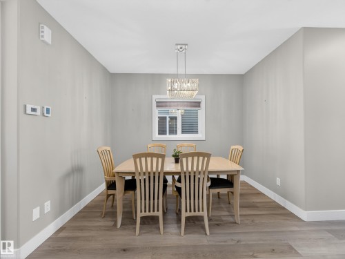 Dining area with light wood-type flooring and suspended lighting - 9358 Pear Link Link, Edmonton, AB - Indoor Photo Showing Dining Room