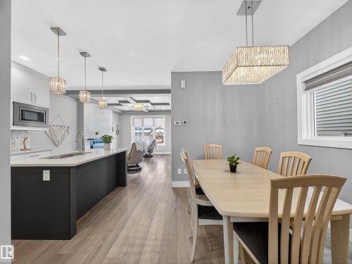 Dining space with hanging lights, light wood-style flooring, and beam ceiling - 9358 Pear Link Link, Edmonton, AB - Indoor Photo Showing Dining Room