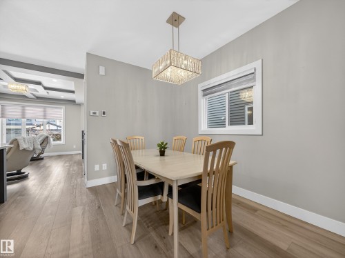 Dining room featuring light wood-style flooring and hanging lights - 9358 Pear Link Link, Edmonton, AB - Indoor Photo Showing Dining Room
