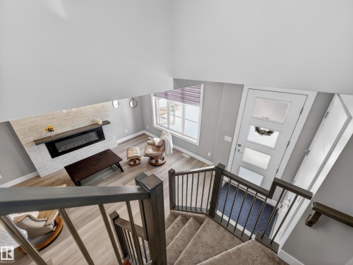 Stairs with a high ceiling and a glass covered fireplace - 9358 Pear Link Link, Edmonton, AB - Indoor Photo Showing Other Room