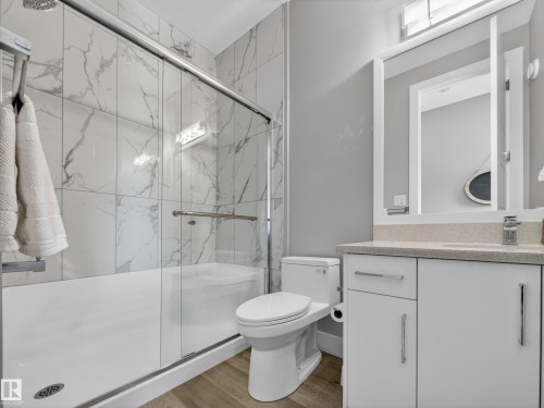 Full bathroom featuring vanity, a marble finish shower, and light wood-style flooring - 9358 Pear Link Link, Edmonton, AB - Indoor Photo Showing Bathroom