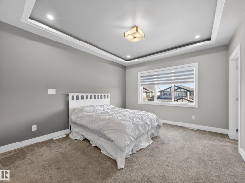 Carpeted bedroom featuring a tray ceiling and recessed lighting - 9358 Pear Link Link, Edmonton, AB - Indoor Photo Showing Bedroom