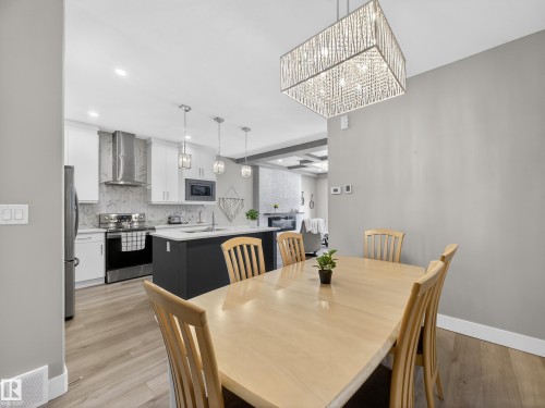 Dining space with light wood-style flooring and a chandelier - 9358 Pear Link Link, Edmonton, AB - Indoor Photo Showing Dining Room