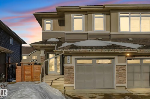 Contemporary house featuring an attached garage, stone siding, and driveway - 97 James Cres, St. Albert, AB - Outdoor