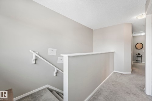 Hallway featuring carpet flooring, an upstairs landing, and a textured ceiling - 97 James Cres, St. Albert, AB - Indoor Photo Showing Other Room