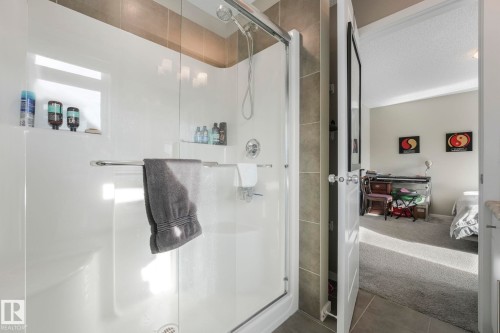 Full bathroom with a shower stall, ensuite bathroom, carpet, tile patterned flooring, and a textured ceiling - 97 James Cres, St. Albert, AB - Indoor Photo Showing Bathroom