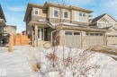 View of front of house featuring concrete driveway, stone siding, an attached garage, and a gate - 97 James Cres, St. Albert, AB  - Outdoor 