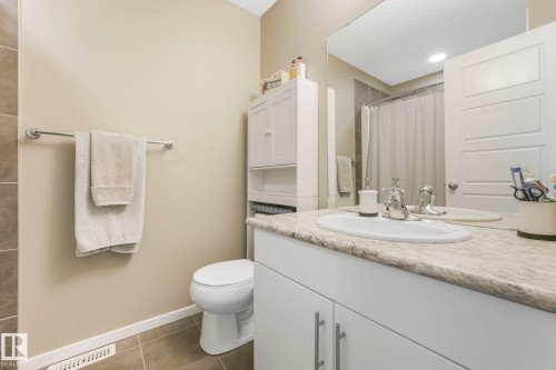 Bathroom featuring curtained shower, vanity, dark tile patterned flooring, and a textured ceiling - 97 James Cres, St. Albert, AB - Indoor Photo Showing Bathroom