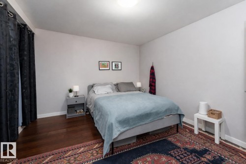 Bedroom featuring dark wood-type flooring and baseboards - 7 10525 83 Avenue, Edmonton, AB - Indoor Photo Showing Bedroom