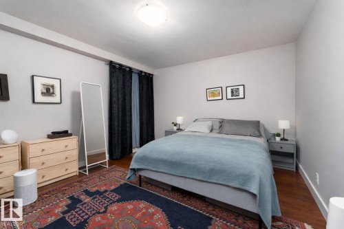 Bedroom featuring dark wood-style flooring and baseboards - 7 10525 83 Avenue, Edmonton, AB - Indoor Photo Showing Bedroom