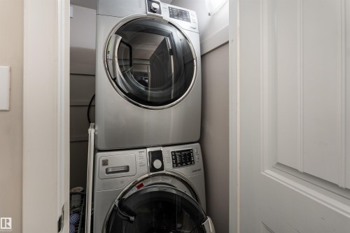 Laundry area with stacked washer / drying machine - 7 10525 83 Avenue, Edmonton, AB - Indoor Photo Showing Laundry Room