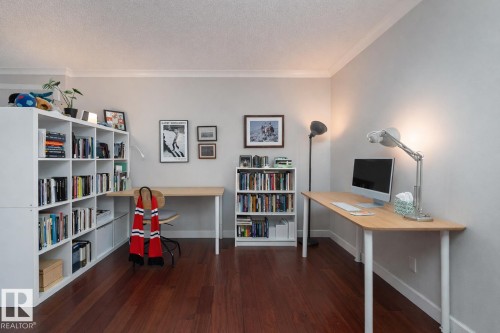 Office with dark wood finished floors, crown molding, and a textured ceiling - 7 10525 83 Avenue, Edmonton, AB - Indoor Photo Showing Office