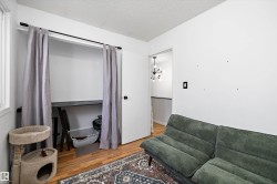 Living area featuring a textured ceiling, wood finished floors, and a chandelier - 