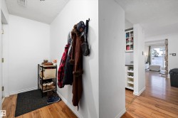 Hall featuring a textured ceiling and light wood-style flooring - 