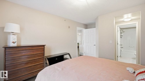 Bedroom with a textured ceiling and ensuite bath - 401 636 Mcallister Loop, Edmonton, AB - Indoor Photo Showing Bedroom