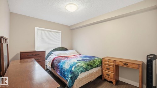 Bedroom featuring dark wood-style flooring and a textured ceiling - 401 636 Mcallister Loop, Edmonton, AB - Indoor Photo Showing Bedroom