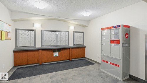 View of community featuring mail area and a textured ceiling - 401 636 Mcallister Loop, Edmonton, AB - Indoor Photo Showing Other Room