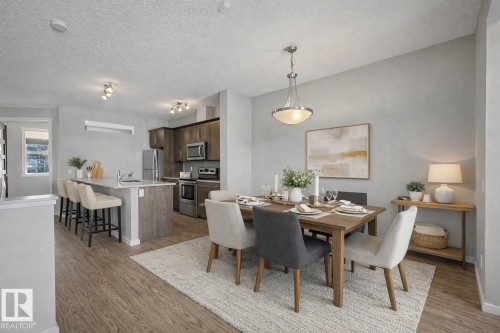 Dining area with light wood-type flooring and a textured ceiling - 2577 Coughlan Road, Edmonton, AB - Indoor Photo Showing Dining Room