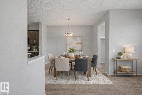 Dining room with light wood finished floors and a textured ceiling - 2577 Coughlan Road, Edmonton, AB - Indoor Photo Showing Dining Room